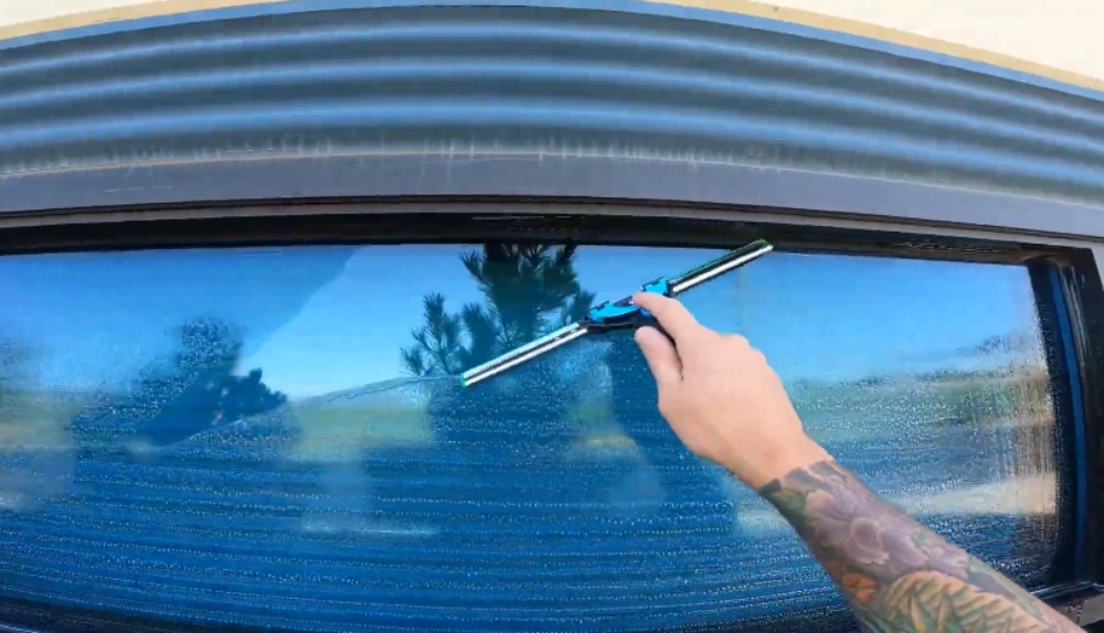 Close-up of detail squeegee tool cleaning a small commercial window pane in San Clemente